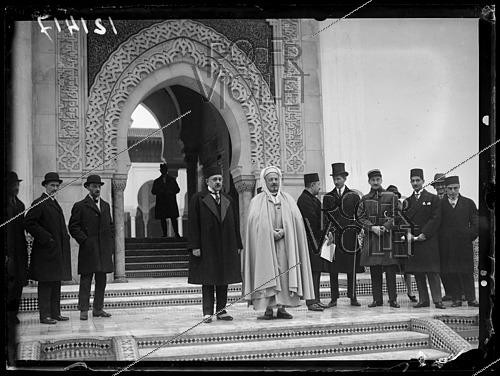 Roger-Viollet | 1429733 | A Persian carpet presented by the government of the Shah of Persia to the French government, intended for the Paris Mosque. Mr. Ben Ghabrit, president of the Society of the Habous of the Holy Places; Mr. Assad Bahador, minister of the Persian government in Paris; and Mr. Jean Gout, minister plenipotentiary. Paris (5th arrondissement), January 12, 1927. Photograph from the newspaper  Excelsior.  | &copy; Excelsior - L'Equipe / Roger-Viollet
