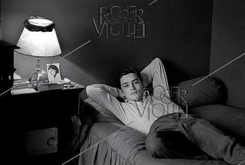 Roger-Viollet | 1643924 | Alain Delon (1935–2024), French actor, at his place, Quai Malaquais, Paris (6th arrondissement), circa 1958. Photograph by Philippe R. Doumic (1927–2013). | &copy; Philippe R. Doumic / Roger-Viollet