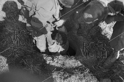 Roger-Viollet | 1082276 | Algerian War of Independence. Harkis, from the 158th Infantry Batalion based in the Mascara Area, at the fort of M'Zaourat during a routine operation. A suspect was found hiding in a hole. Algeria, Summer 1961. | &copy; Jean-Pierre Laffont / Roger-Viollet