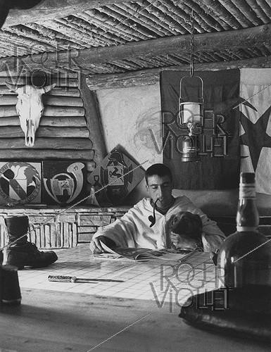 Roger-Viollet | 349862 | Algerian War of Independence. The French Army's fort in M'Zaourat, Mascara Area. The Sub-lieutenant Jean-Pierre Laffont, platoon commander, in the room serving as dining room, bedroom and office. Algeria, Summer 1961. | &copy; Jean-Pierre Laffont / Roger-Viollet