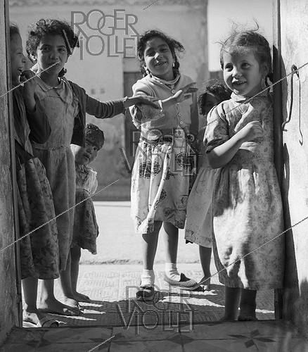 Roger-Viollet | 922916 | Algerian War of Independence. The mischievous children of the village observing the soldier Jean Pierre Laffont in his new bedroom. Dublineau (present Hacine), in the Mascara Area. Algeria, April 1961. | &copy; Jean-Pierre Laffont / Roger-Viollet