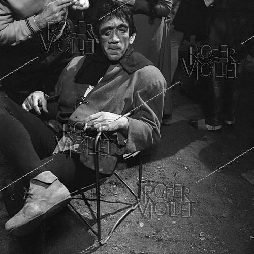Roger-Viollet | 596072 | Anthony Quinn during the shooting of  Notre-Dame de Paris  by Jean Delannoy. Paris, in 1956. | &copy; Alain Adler / Roger-Viollet