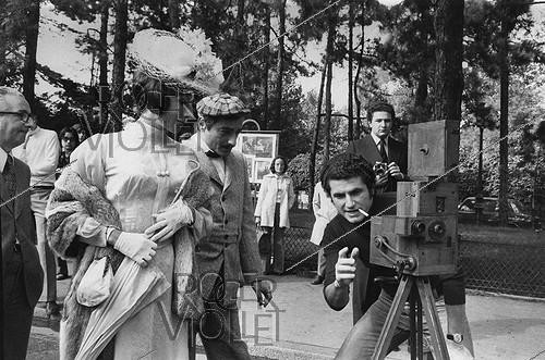 Roger-Viollet | 1375932 | Claude Lelouch (born in 1937), French film director, with his collector movie camera and the actors Judith Magre (born in 1926) and Charles Denner (1926-1995). First day of shooting of  Toute une vie . Paris, Porte Dauphine, on September 2nd, 1973. Photograph by André Perlstein (born in 1942). | &copy; André Perlstein / Roger-Viollet