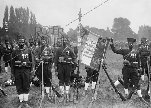 Roger-Viollet | 962865 | Flag of the 1st regiment of Senegalese infantrymen at the Longchamp racecourse. Paris (16th arrondissement), on July 14, 1913. | &copy; Maurice-Louis Branger / Roger-Viollet