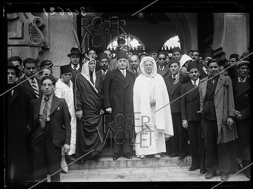 Roger-Viollet | 232251 | Les notabilités musulmanes se réunissent pour la fête de l'Aïd el-Kébir durant laquelle sont sacrifiés des moutons, en la présence de Si Kaddour ben Ghabrit, habillé en burnous (1868-1954), haut fonctionnaire algérien et fondateur de l'Institut musulman de la Grande Mosquée de Paris et de Mahmoud Fakhry Pasha (1884-1952), ambassadeur d'Égypte en France, à la Grande Mosquée de Paris. Paris (5e arr.), janvier 1940. | &copy; Excelsior - L'Equipe / Roger-Viollet