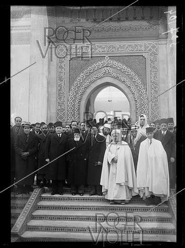 Roger-Viollet | 1073636 | Si Kaddour ben Ghabrit (1868–1954), dressed in a burnous, a high-ranking Algerian official and founder of the Muslim Institute of the Grand Mosque of Paris, Mahmoud Fakhry Pasha (1884–1952), Egyptian ambassador to France, at the Grand Mosque of Paris. Gathering of Muslim dignitaries for the Eid al-Adha holiday, during which sheep are sacrificed. Paris (5th arr.), January 20, 1940. | &copy; Excelsior - L'Equipe / Roger-Viollet