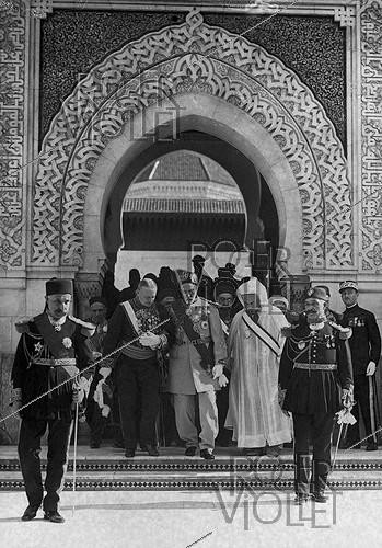 Roger-Viollet | 749700 | The Bey of Tunis, accompanied by Lucien Saint and Si Kaddour Ben Ghabrit, leaving the prayer hall and heading to the gardens of the Grand Mosque of Paris (5th arrondissement), August 1926. | &copy; Roger-Viollet / Roger-Viollet