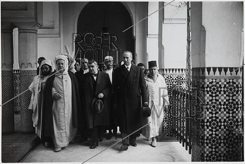 Roger-Viollet | 130139 | World War II. Propaganda photograph: Max Bonnafous (1900–1975) and René Bouffet (1896–1945), French politicians meet Si Kaddour Benghabrit (1868–1954), an Algerian theologian and high-ranking official, at the Grand Mosque of Paris on the day of Mouloud. Paris (5th arrondissement). Photograph from the newspaper  Le Petit Parisien . Paris, Carnavalet Museum. | &copy; Musée Carnavalet / Roger-Viollet