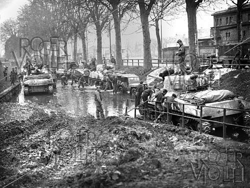 Roger-Viollet | 1421861 | World War II. Tankers cleaning up their equipment mired in floods during the Liberation of Colmar (France), on February 10, 1945. Photograph from the collections of the French newspaper  France-Soir . Bibliothèque historique de la Ville de Paris. | &copy; Fonds France-Soir / BHVP / Roger-Viollet